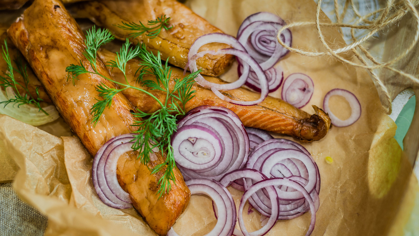 Копченое филе рыбы на бумаге с луком