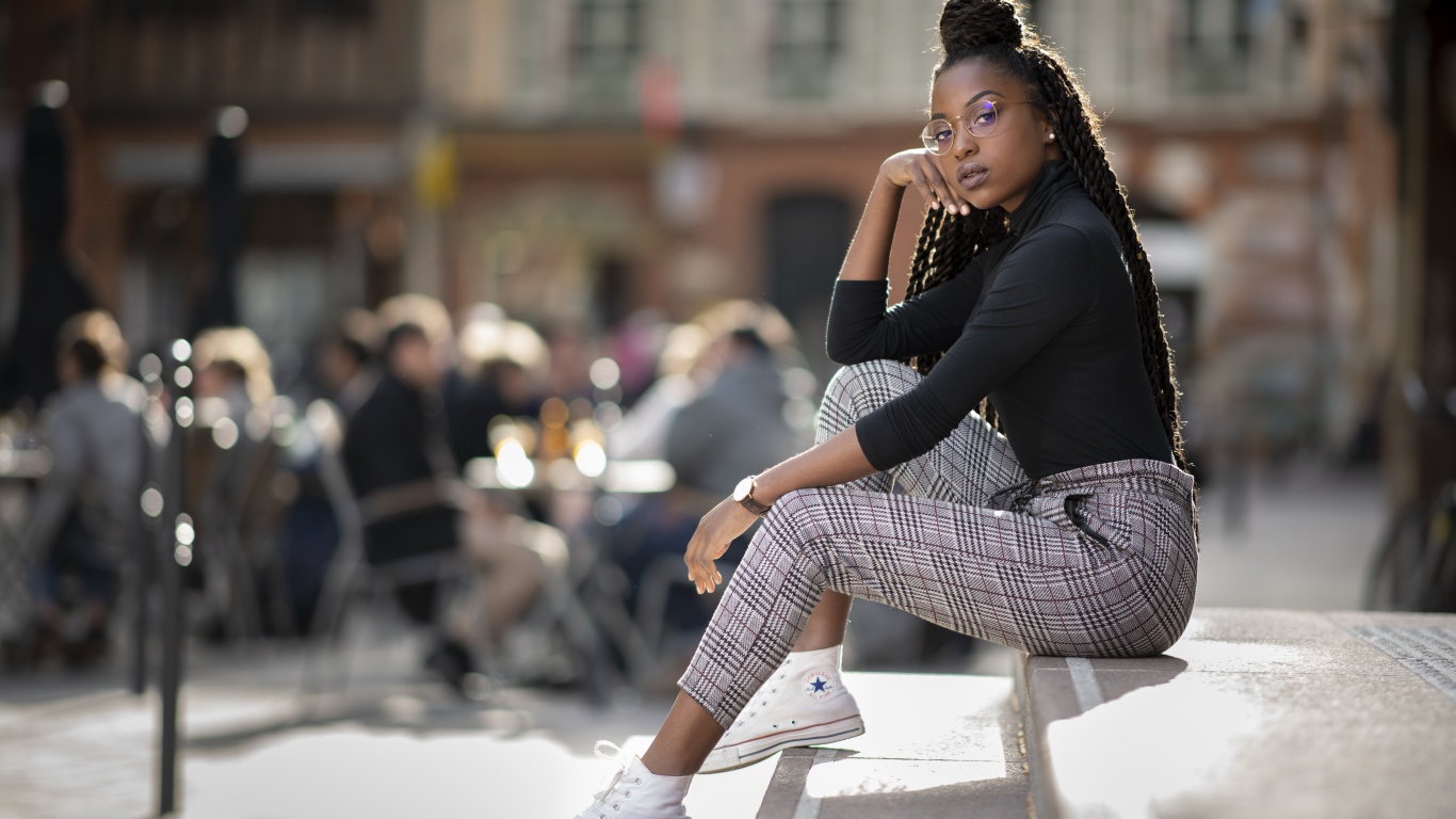 Красивая темнокожая девушка сидит на ступеньках