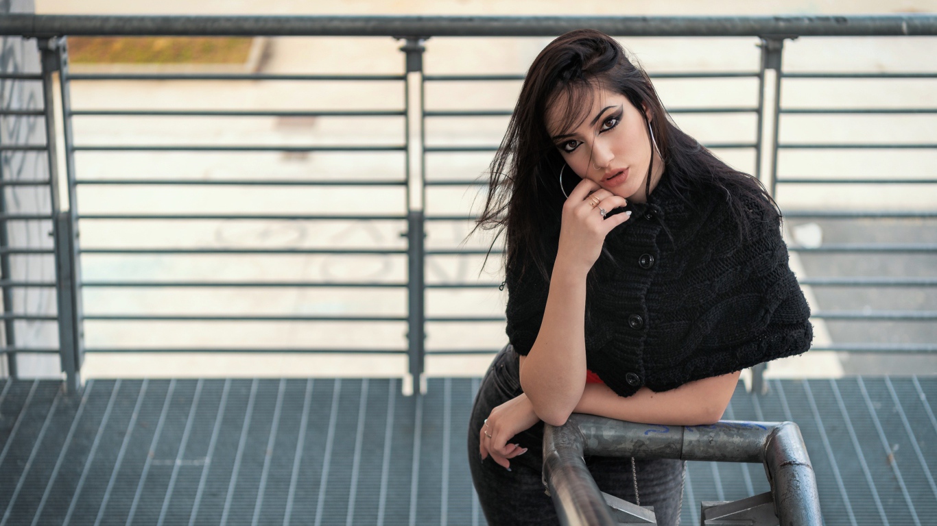 Красивая девушка стоит на ступеньках у перил 