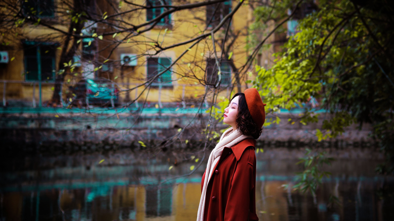 Девушка азиатка в красном пальто у воды