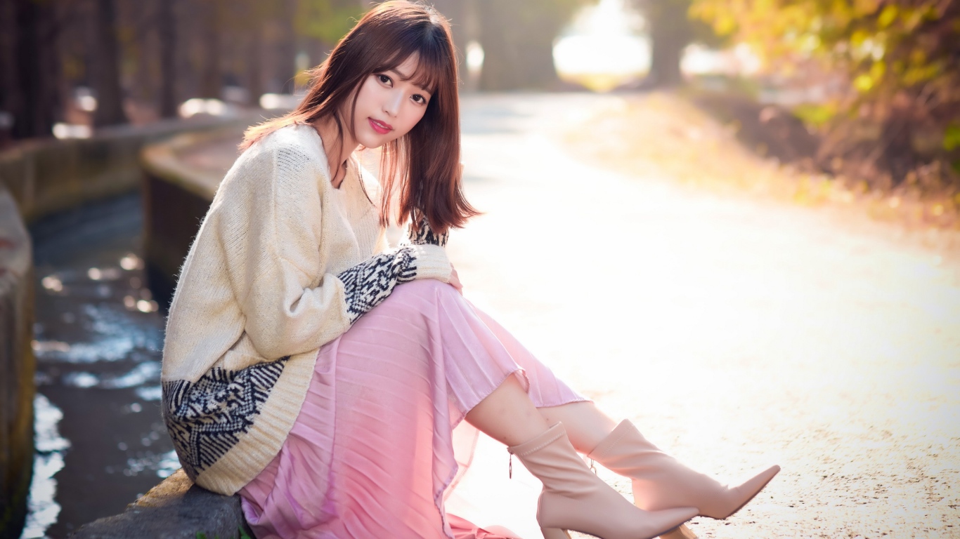 Девушка азиатка сидит на земле 