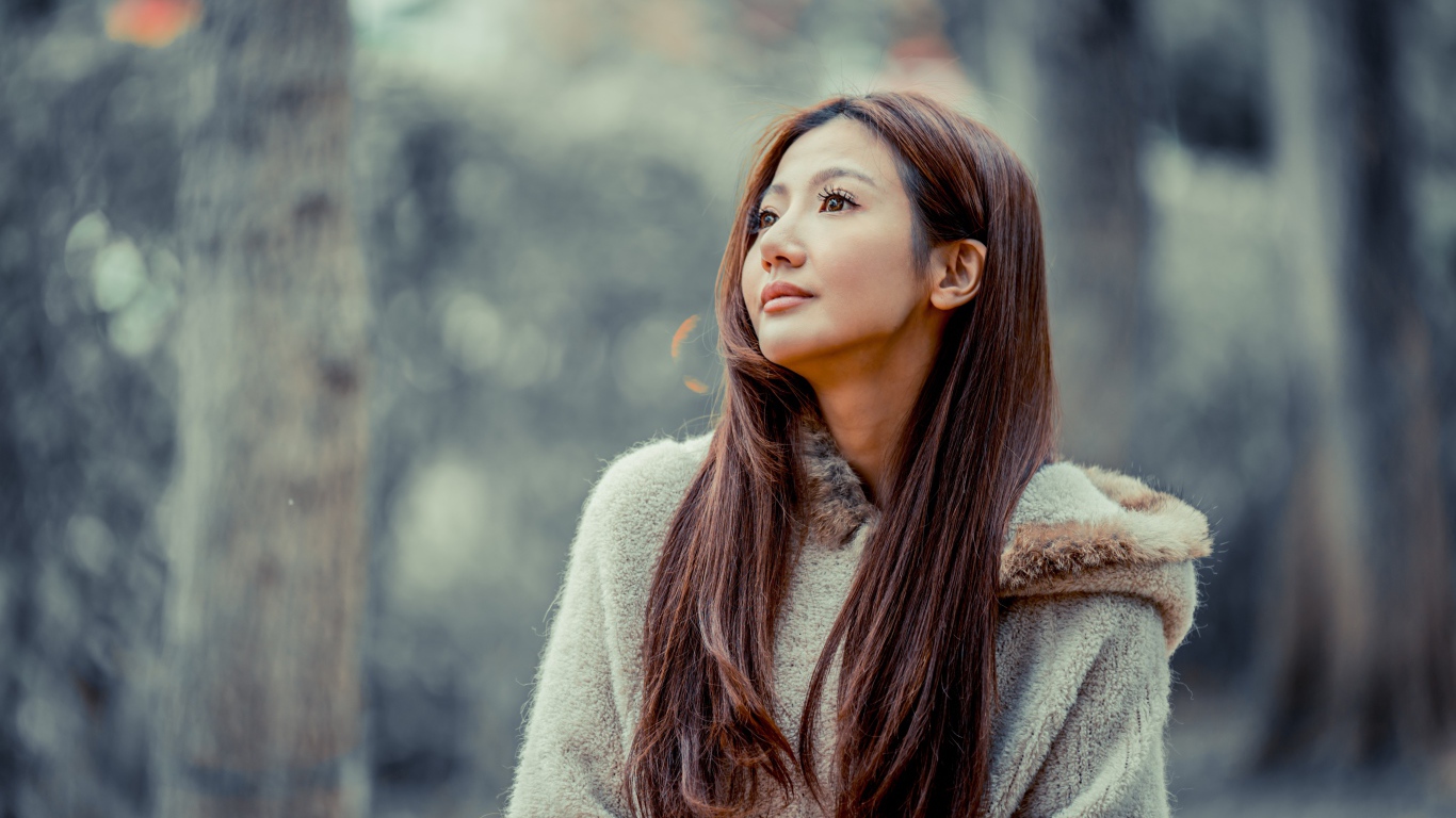 Длинноволосая девушка азиатка смотрит в сторону