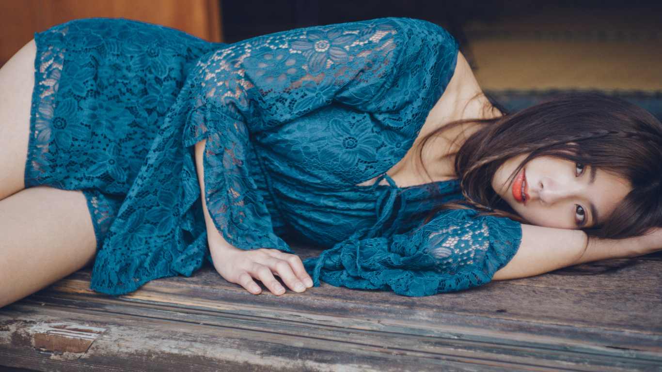 Красивая девушка азиатка в платье лежит на полу