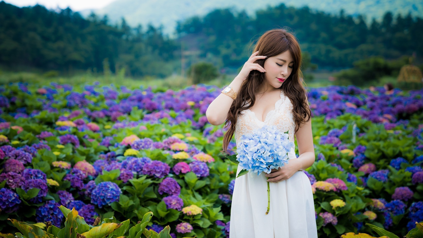 Красивая девушка азиатка в белом платье с цветами гортензии 