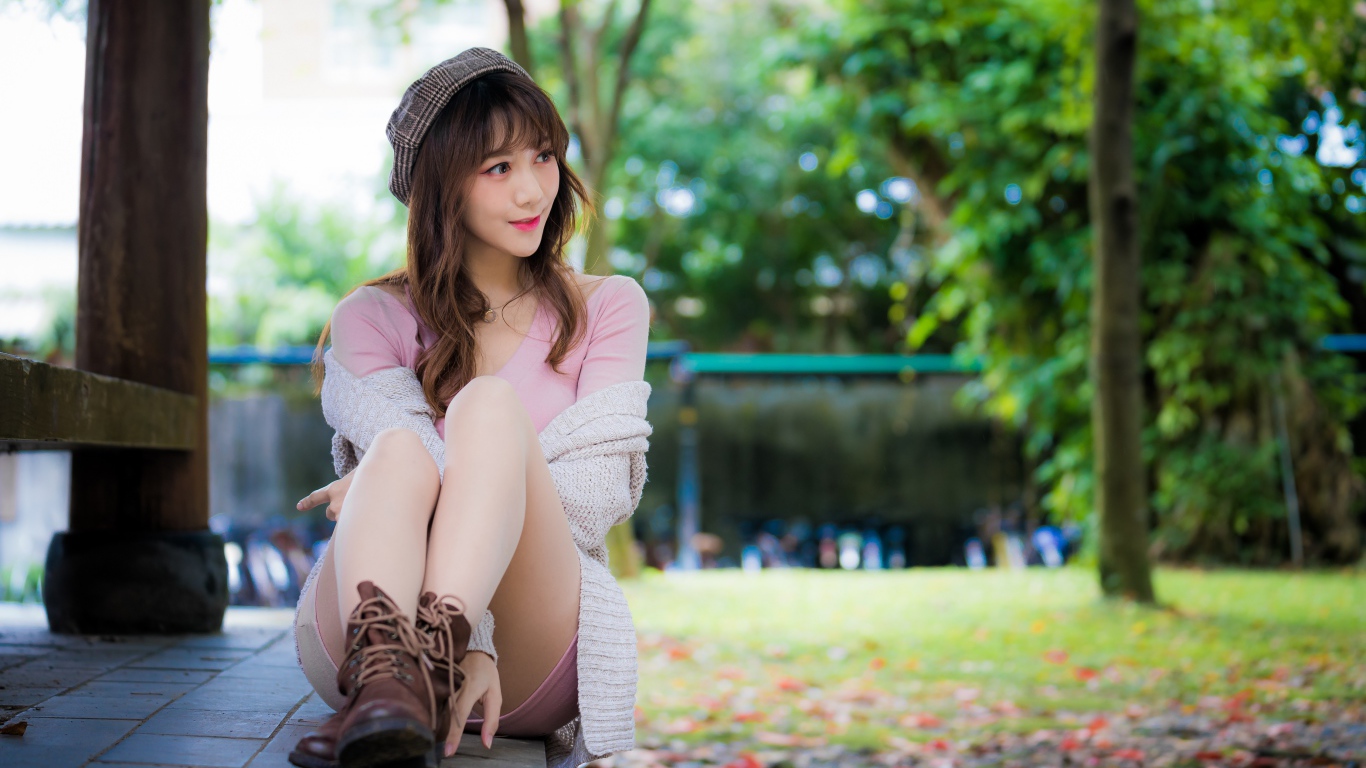 Красивая девушка азиатка сидит на земле 