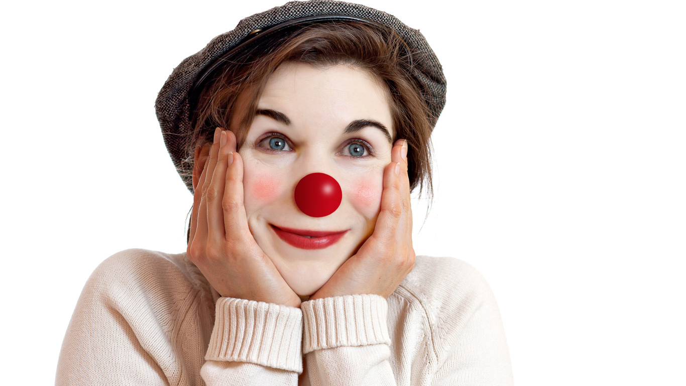 Красивая голубоглазая девушка в кепке с носом клоуна на белом фоне