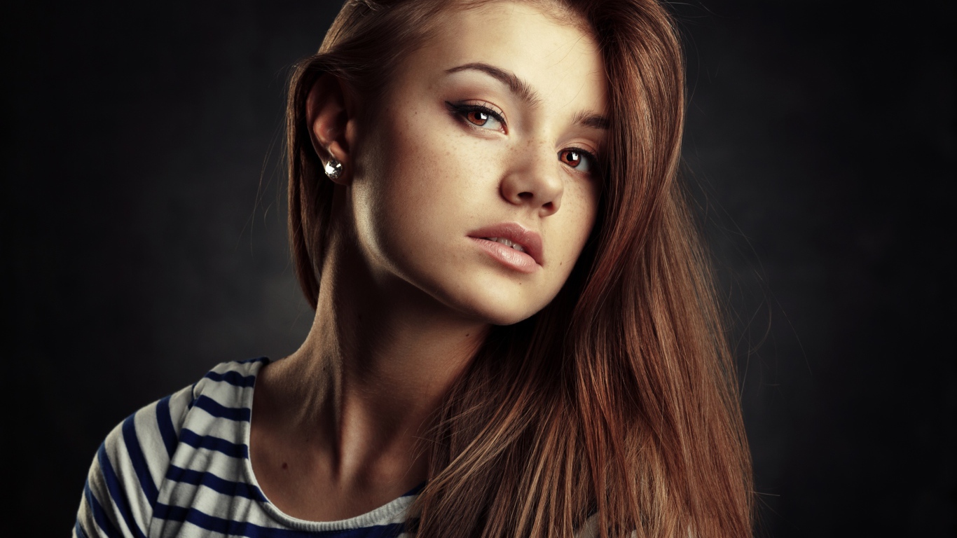 Красивая кареглазая девушка с русыми волосами на сером фоне