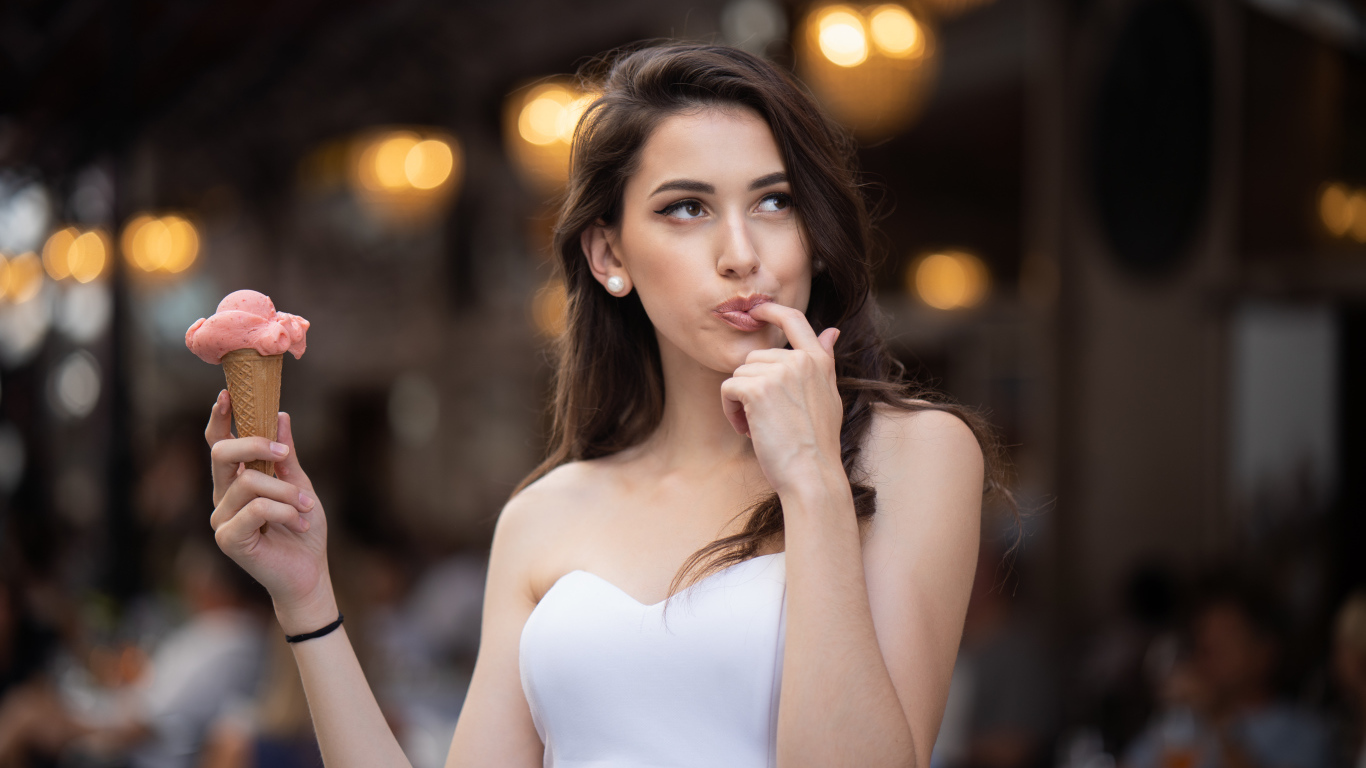 Красивая девушка шатенка с мороженым в руке