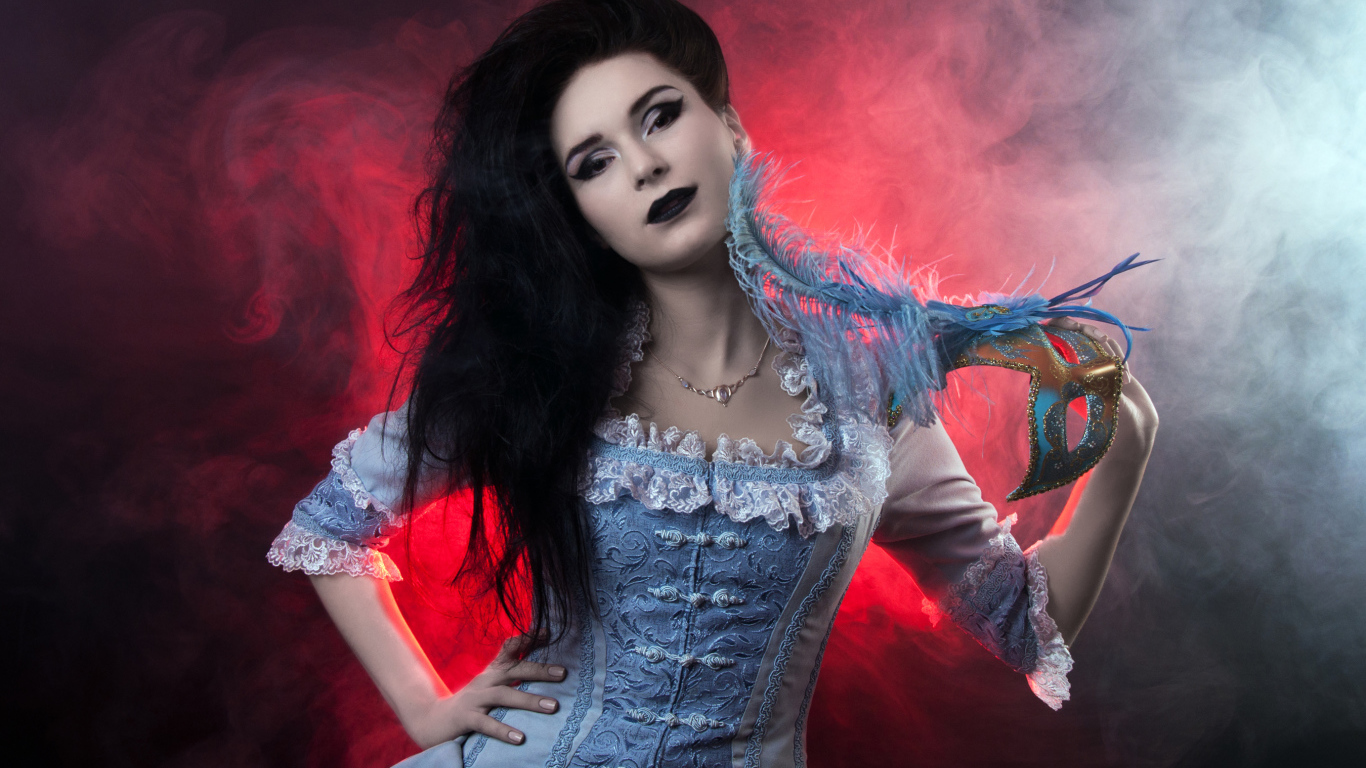 Красивая девушка в старинном платье с маской в руке