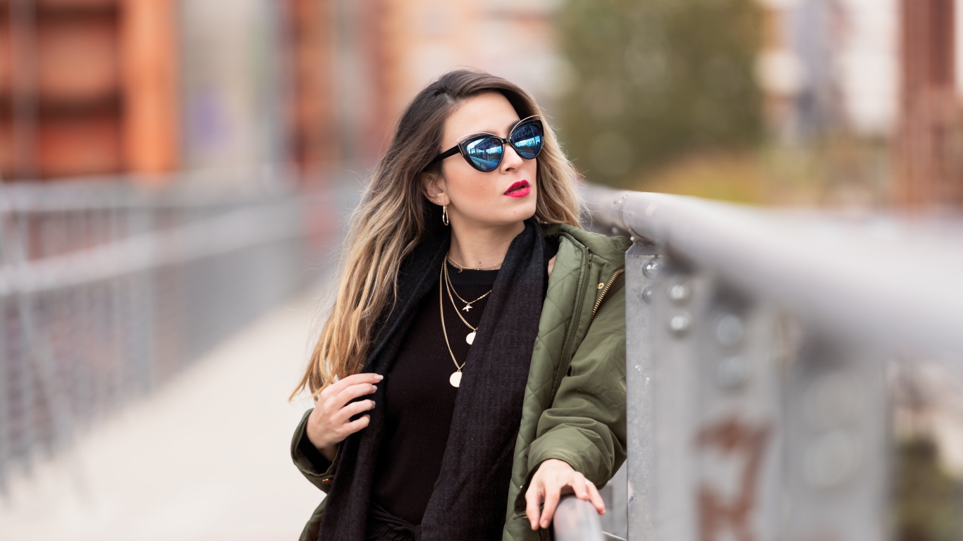 Красивая девушка в солнечных очках на мосту