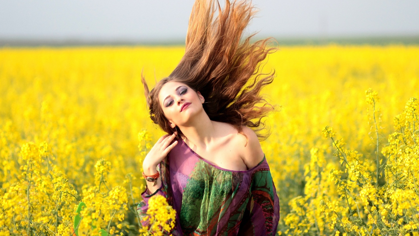 Красивая девушка на поле с желтыми цветами