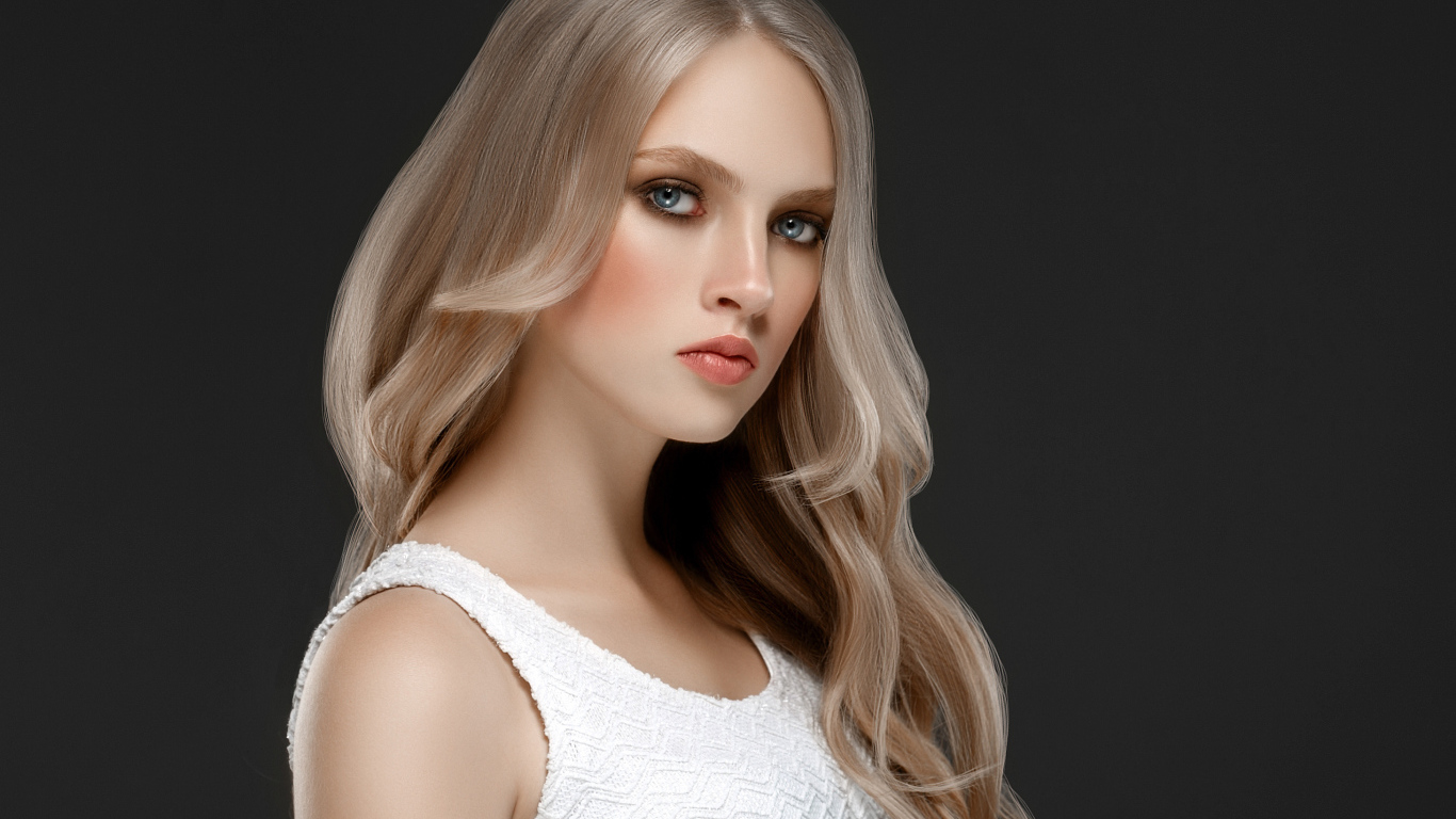 Красивая девушка с длинными  белыми волосами на сером фоне