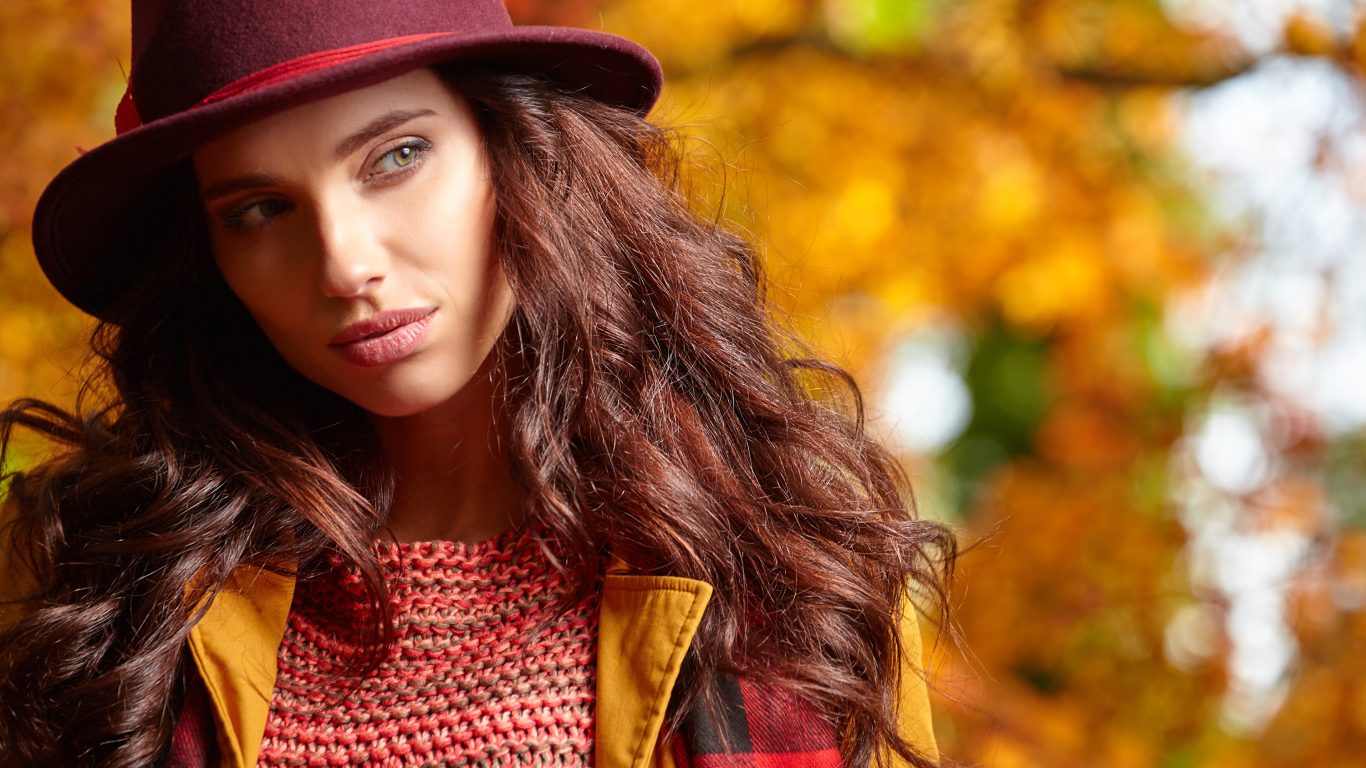 Красивая длинноволосая девушка в шляпе осенью