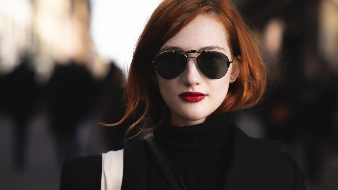 Красивая рыжеволосая девушка в темных очках