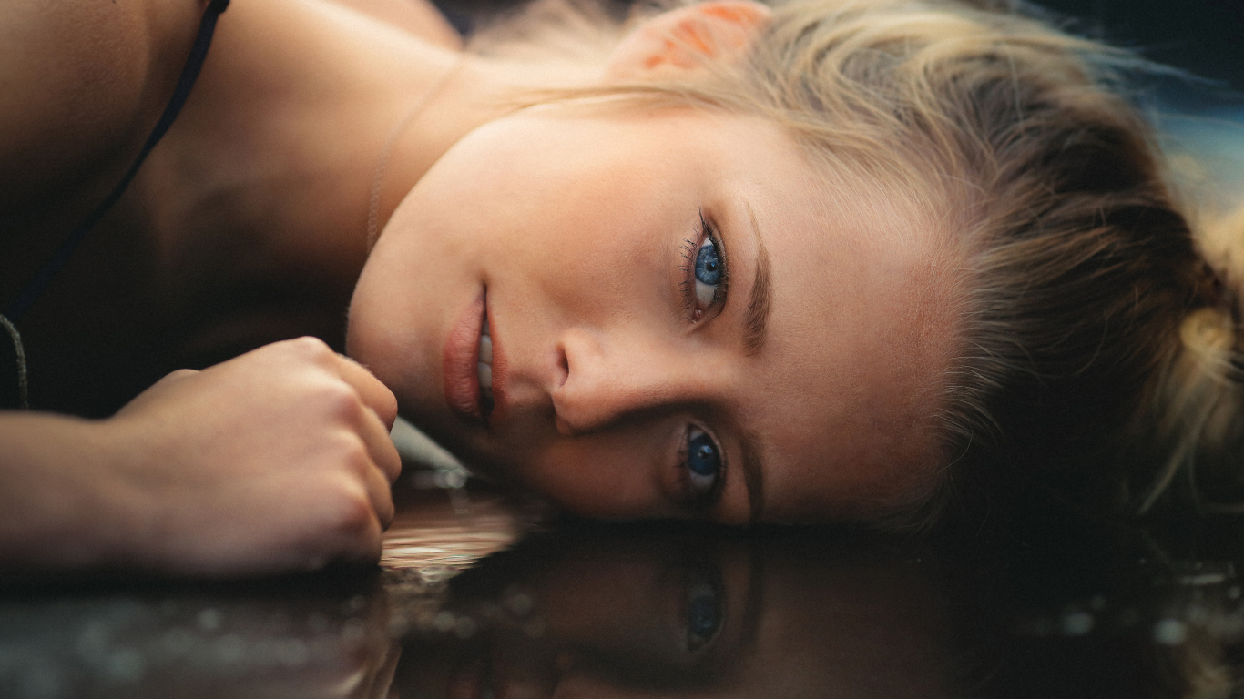 Голубоглазая девушка модель лежит на полу