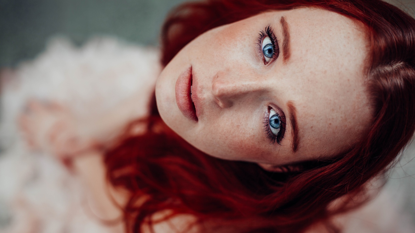 Голубоглазая рыжеволосая девушка с веснушками на лице