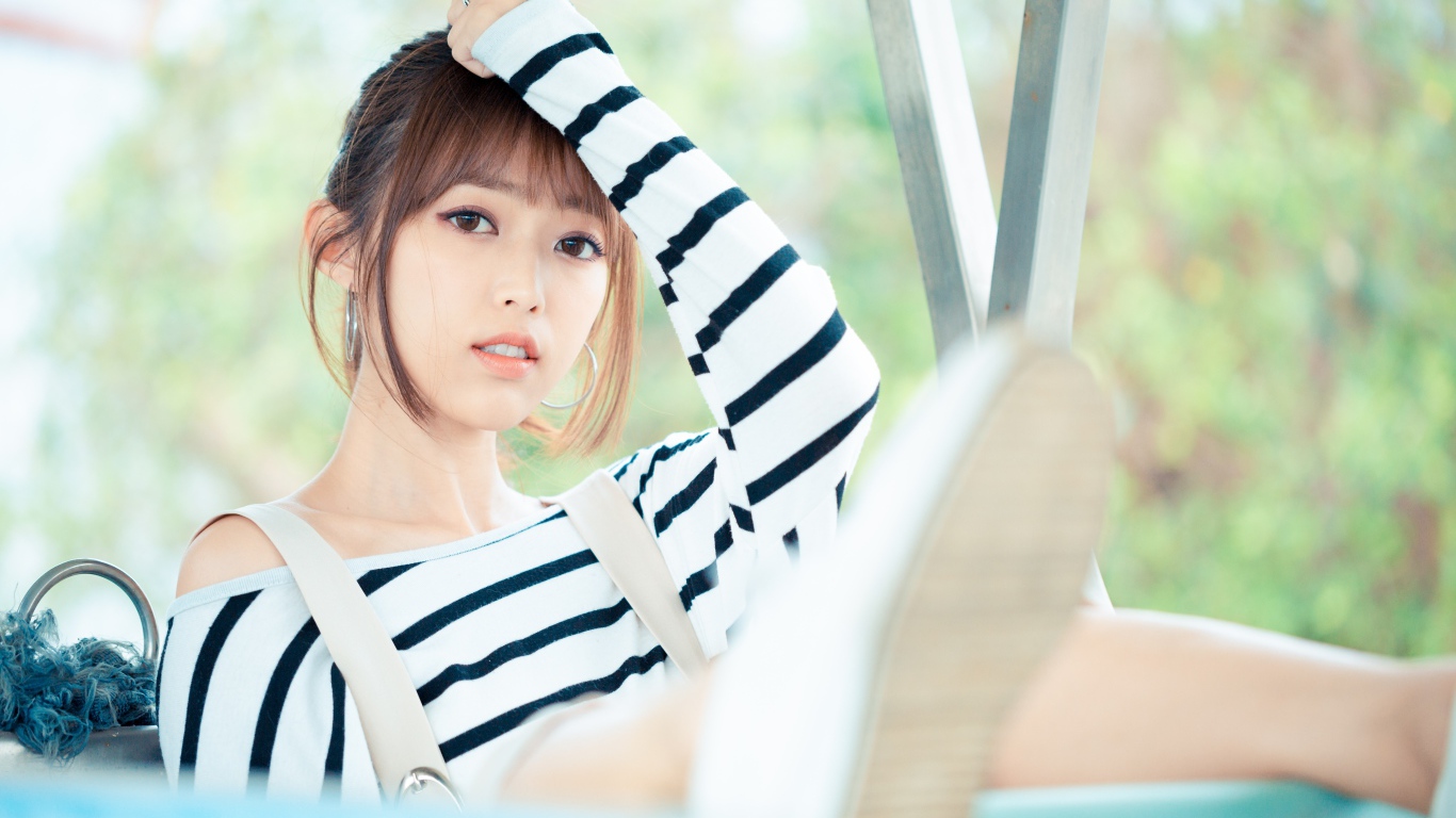 Кареглазая девушка азиатка в полосатом свитере