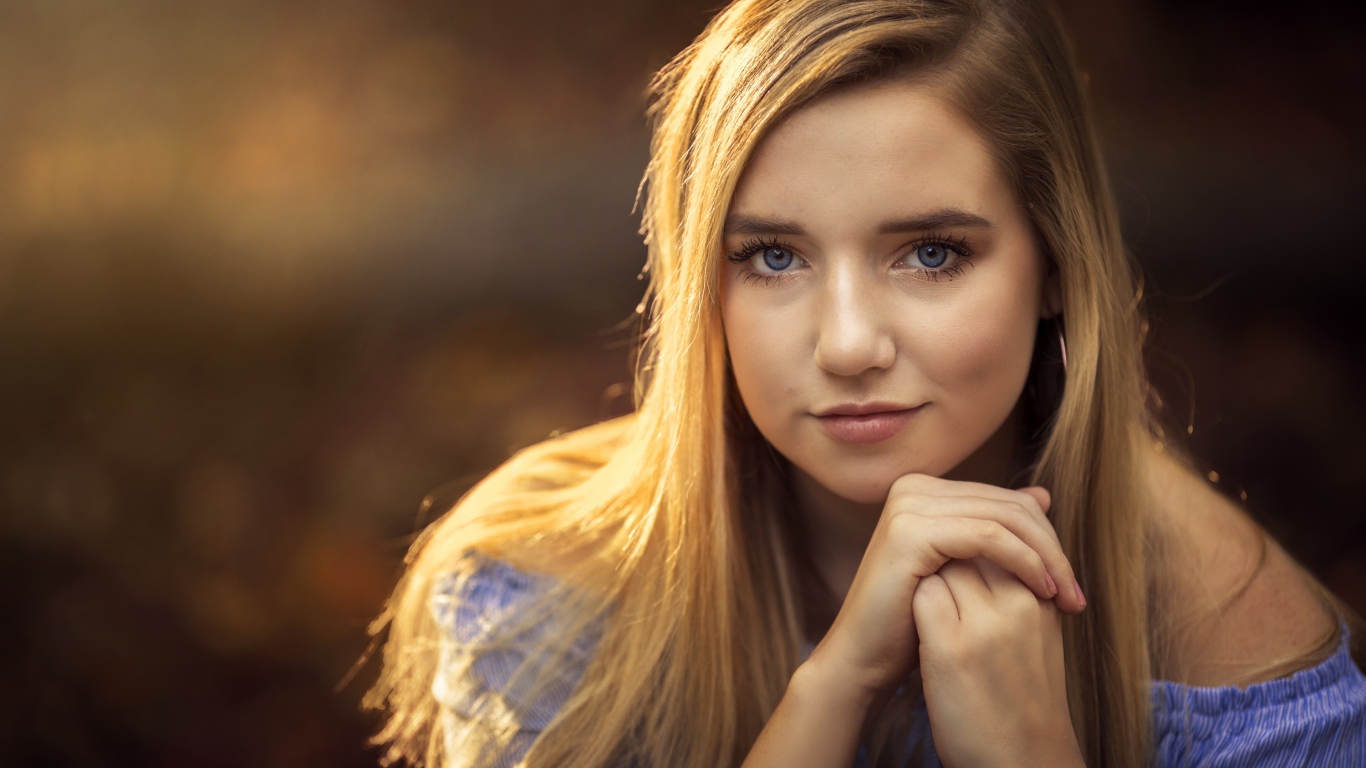 Милая голубоглазая девушка в лучах солнца