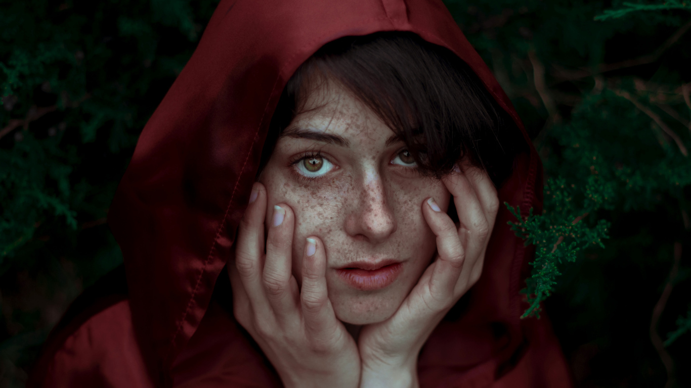 Девушка в красном плаще с веснушками на лице