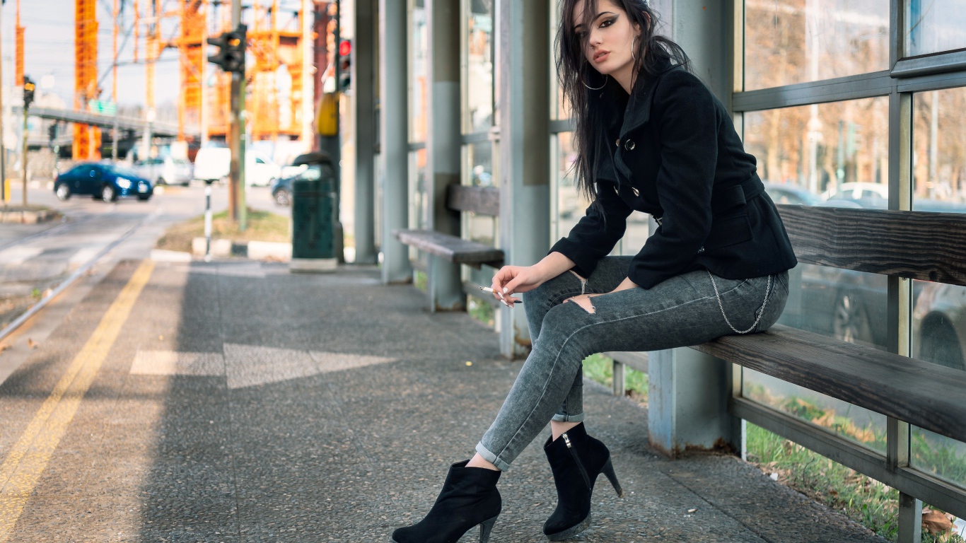 Девушка неформалка сидит на автобусной остановке