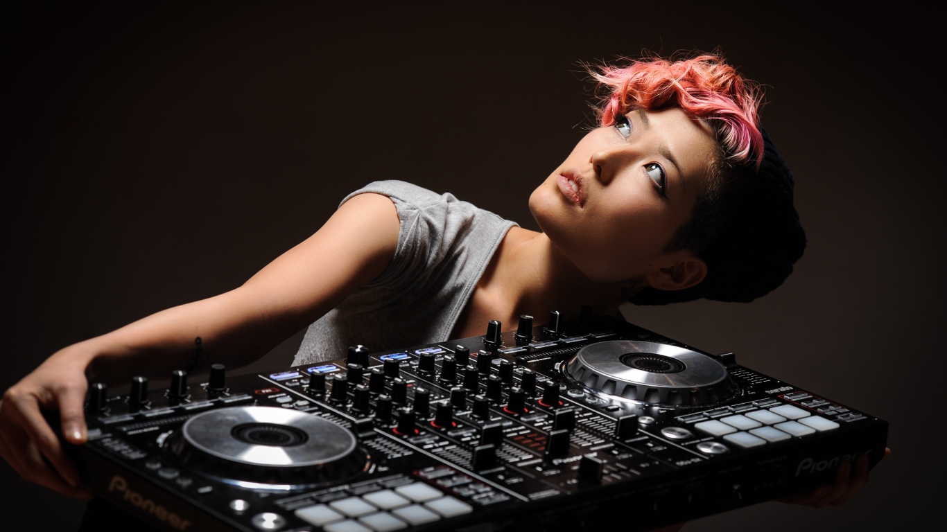 Девушка с розовой челкой с диджейским пультом в руках