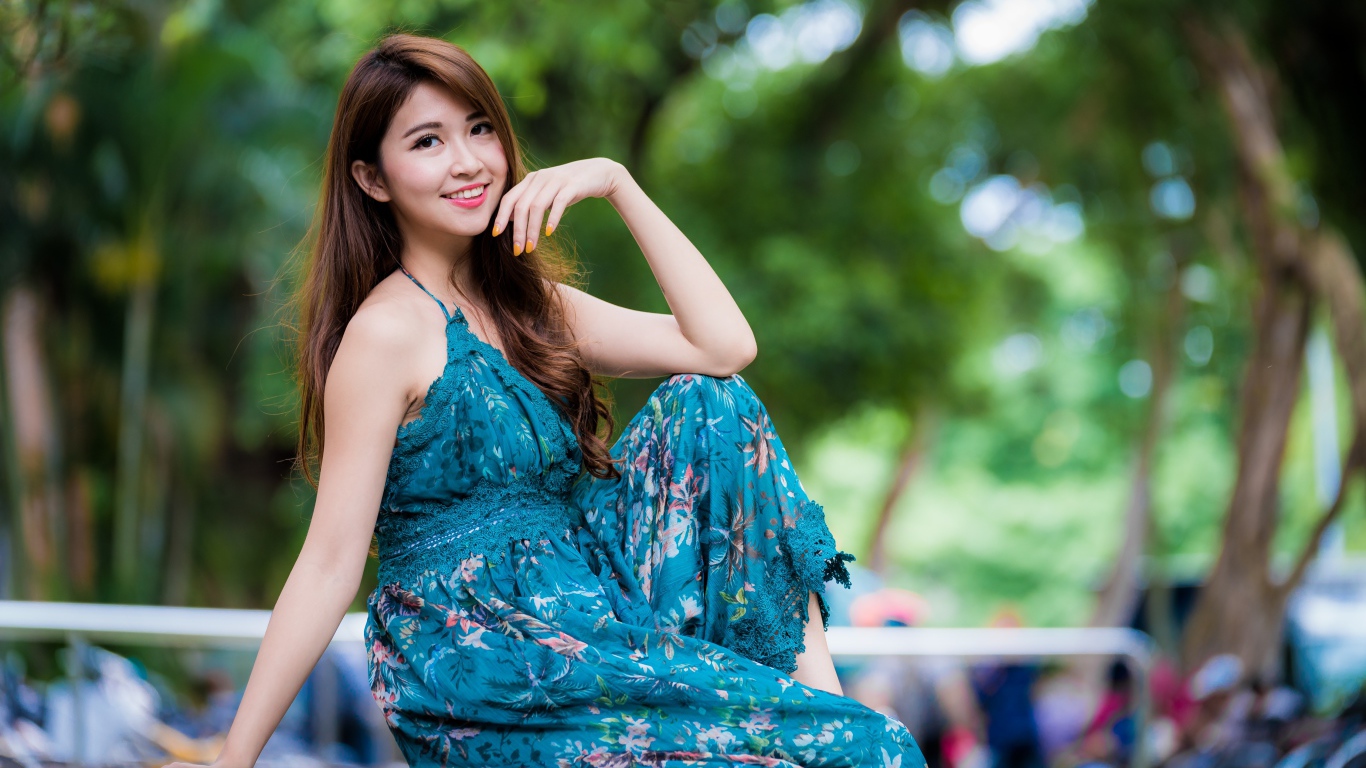 Улыбающаяся азиатка сидит на лавке