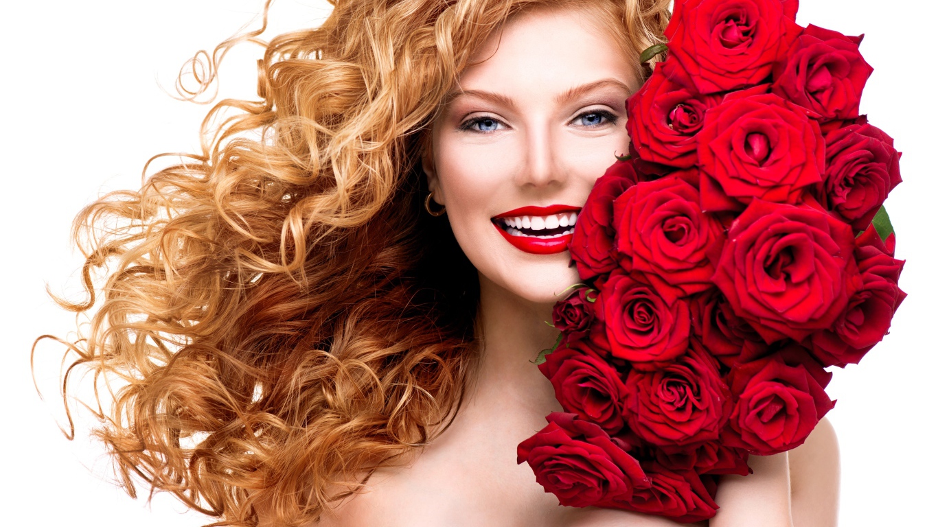Улыбающаяся голубоглазая рыжеволосая девушка с букетом красных роз 