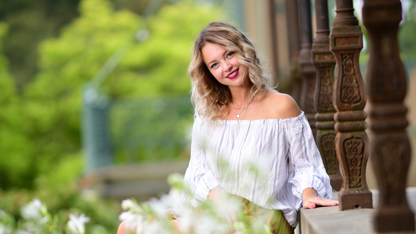 Улыбающаяся девушка сидит на ступенях