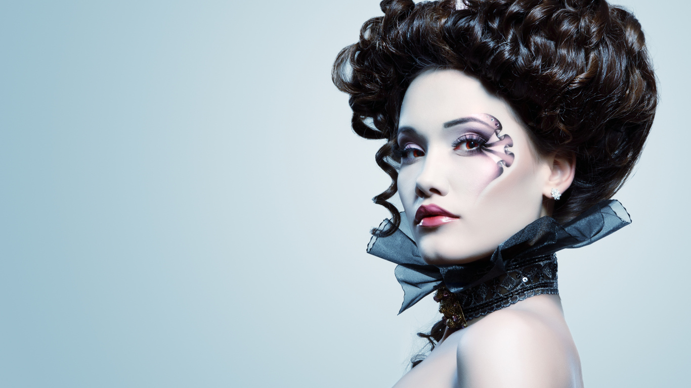 Девушка с необыной прической и макияжем на сером фоне