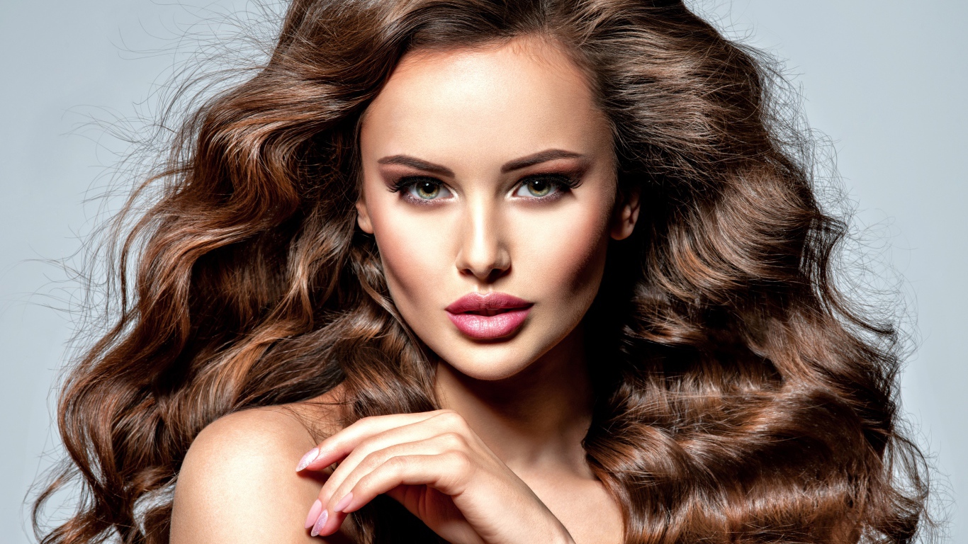 Девушка с красивыми длинными волосами на сером фоне