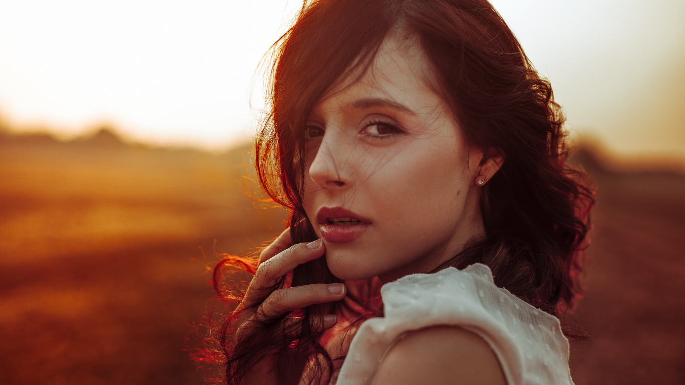 Ветер развивает волосы молодой девушки 