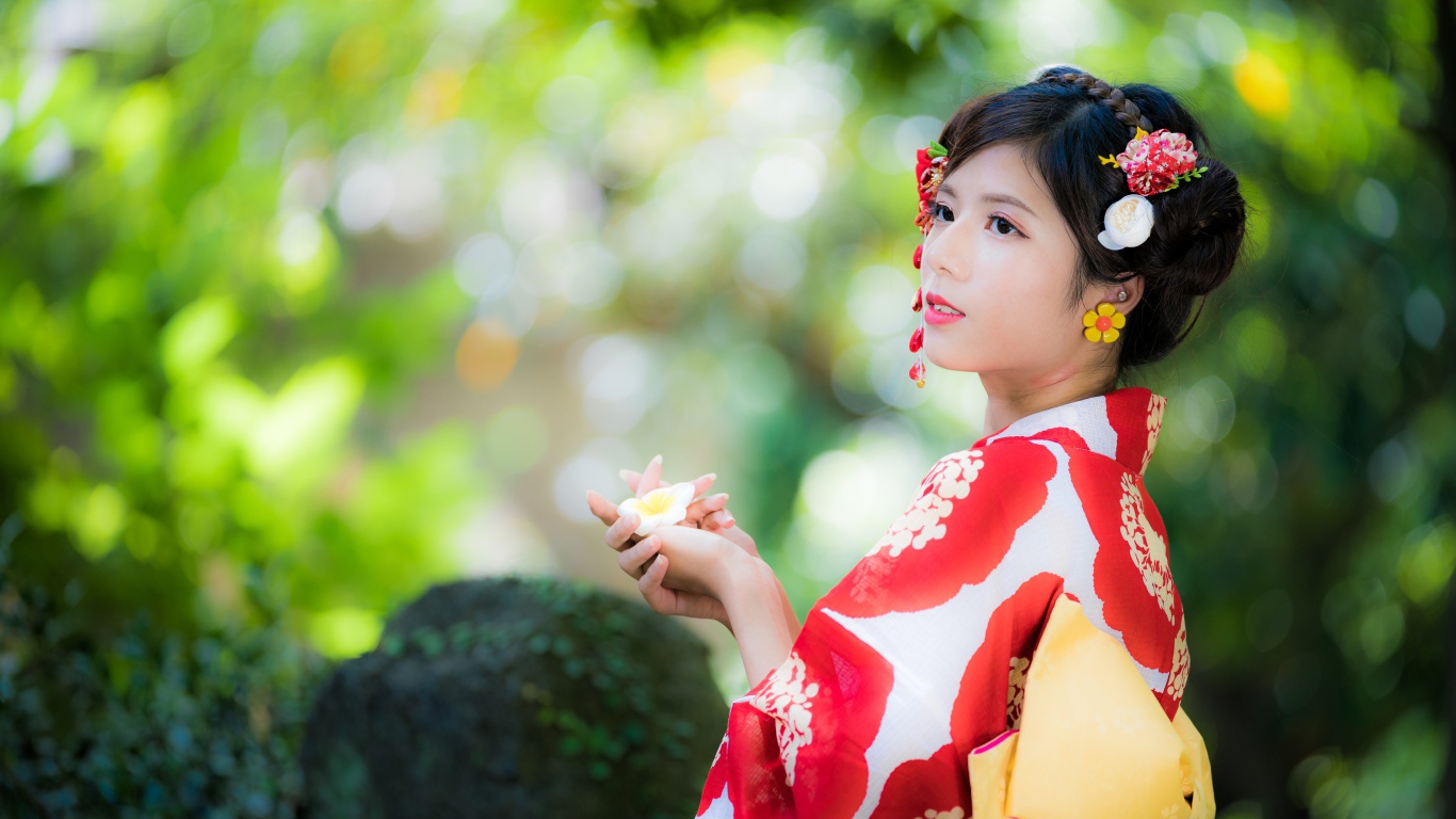 Молодая девушка азиатка в кимоно с цветами в волосах 
