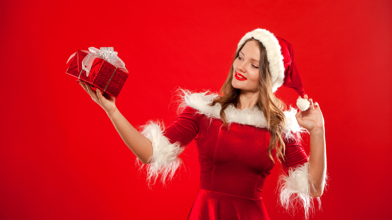 Красивая Снегурочка с подарком в руке на красном фоне