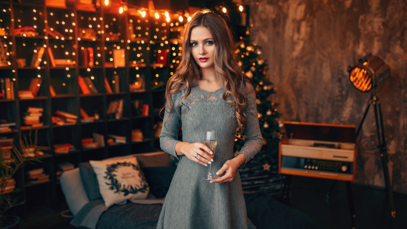 Красивая девушка с бокалом шампанского в комнате украшенной гирляндой