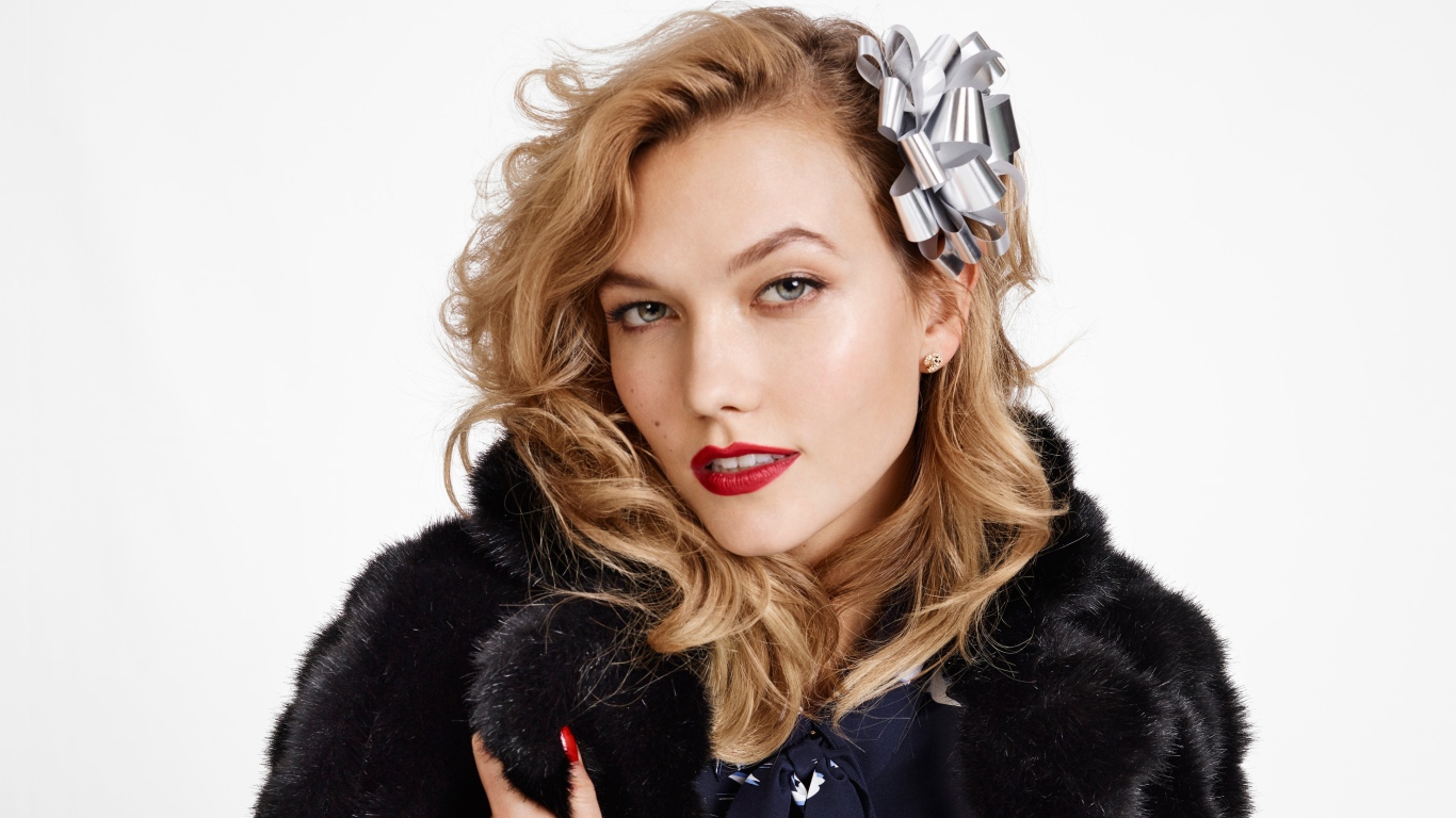 Модель Карли Клосс в черной шубе на белом фоне