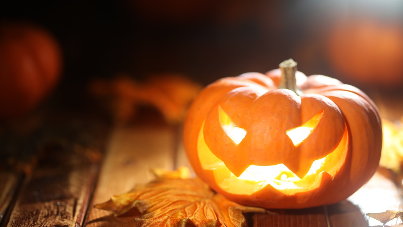 Светящаяся тыква на столе на Хэллоуин