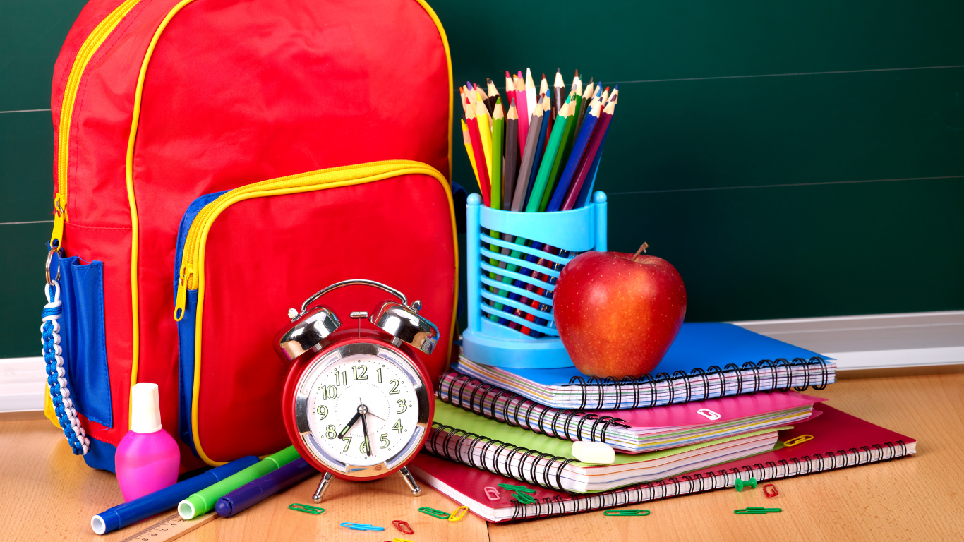 Рюкзак, тетради, карандаши, будильник и яблоко на День знаний 1 сентября
