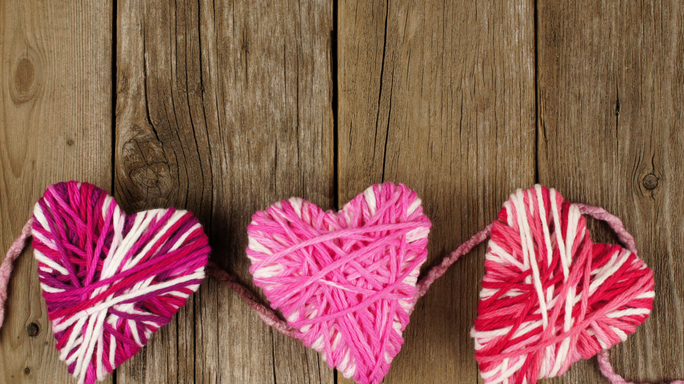 Сердца из ниток на деревянном столе