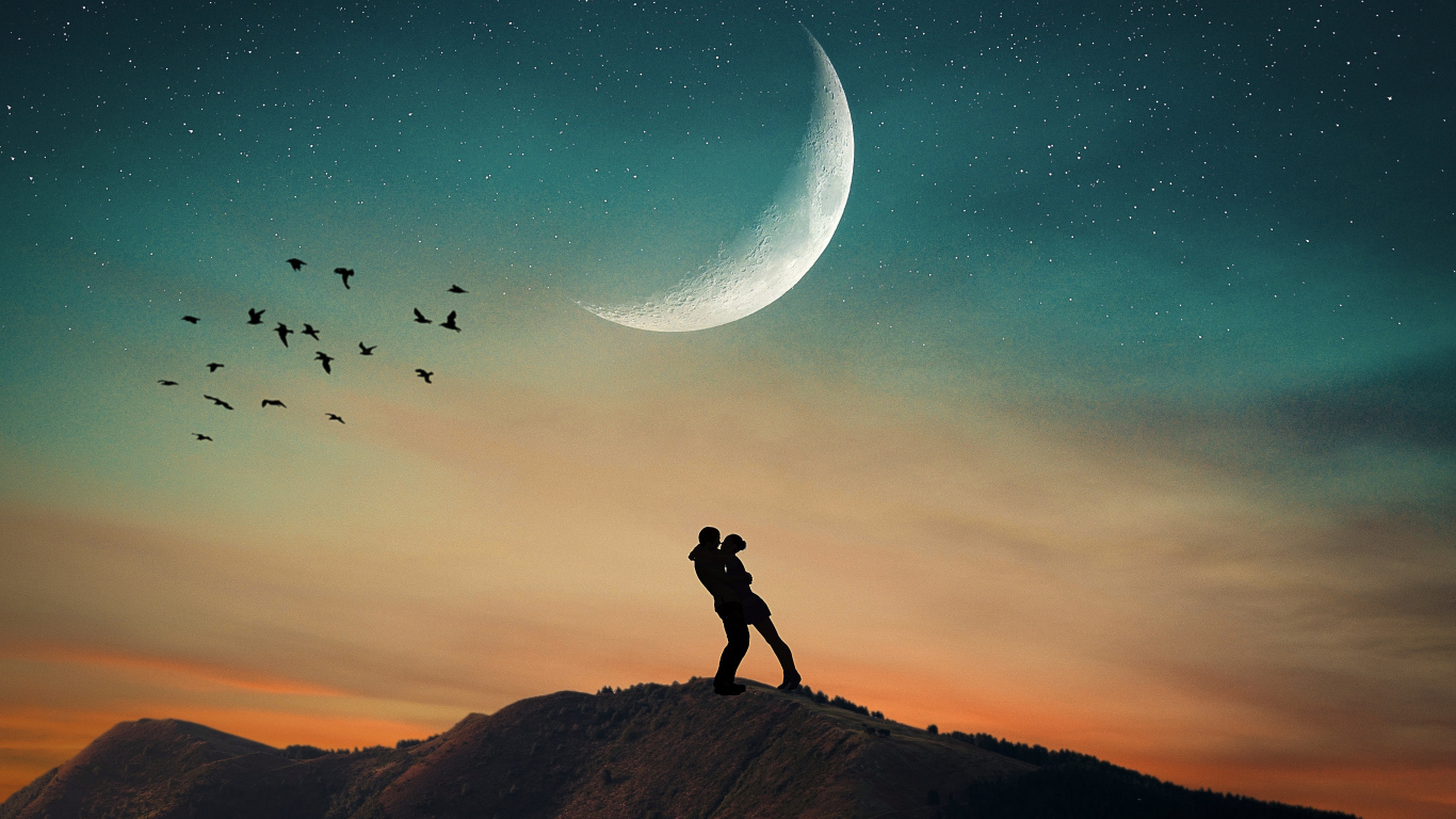 Влюбленная пара стоит на горе на фоне луны 