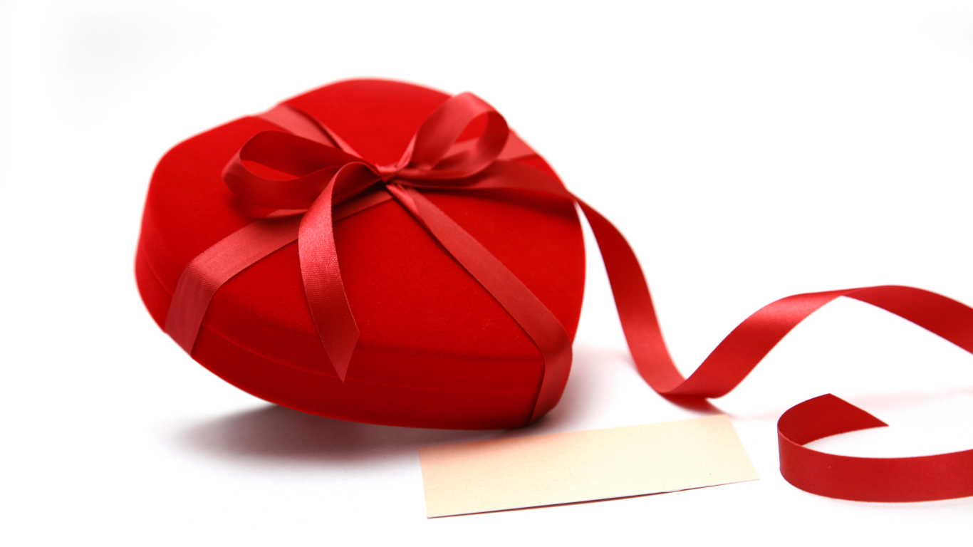 Красная коробка для ювелирных изделий в форме сердца на белом фоне 