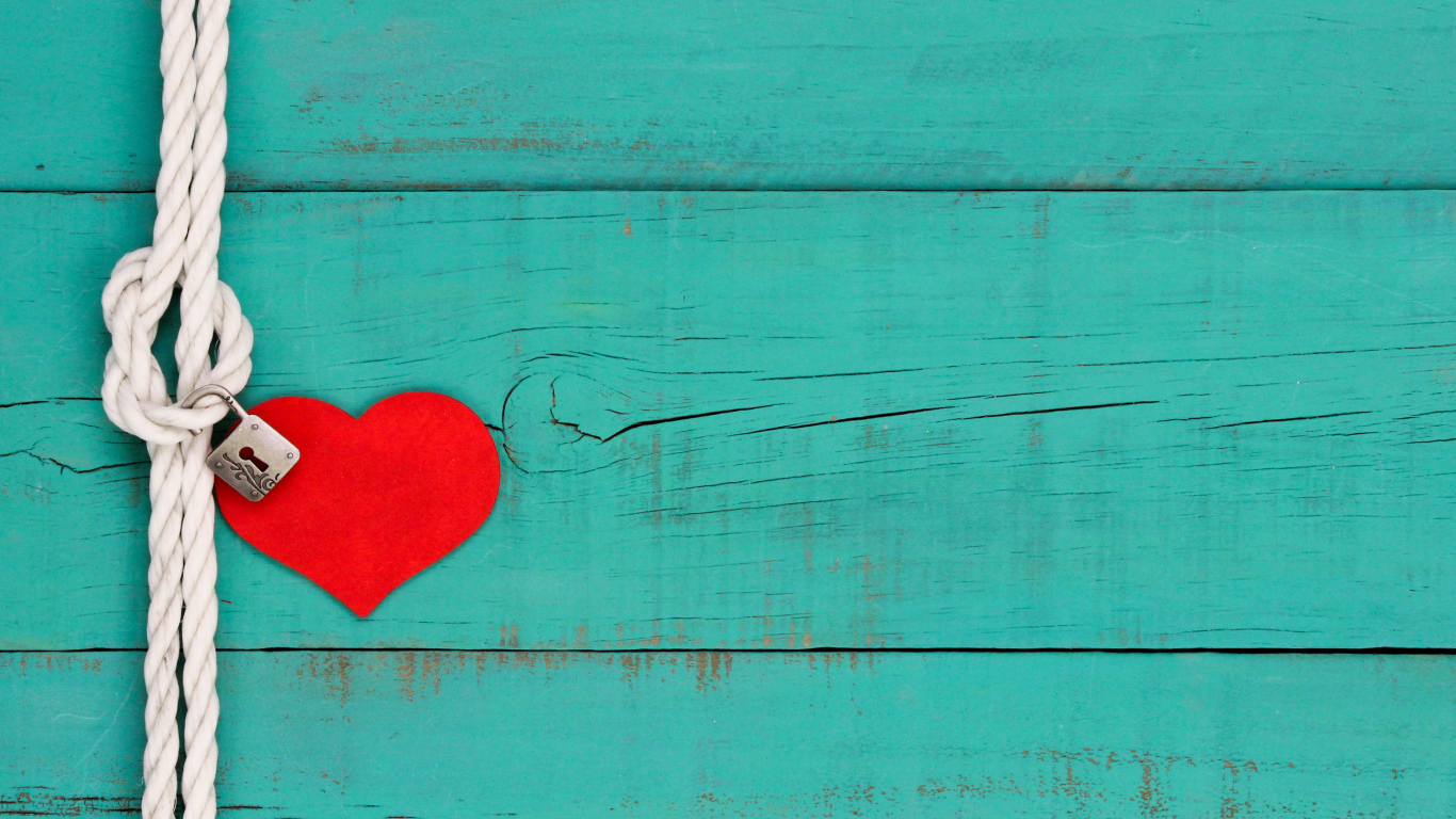 Красное сердечко на веревке с замком на голубом фоне