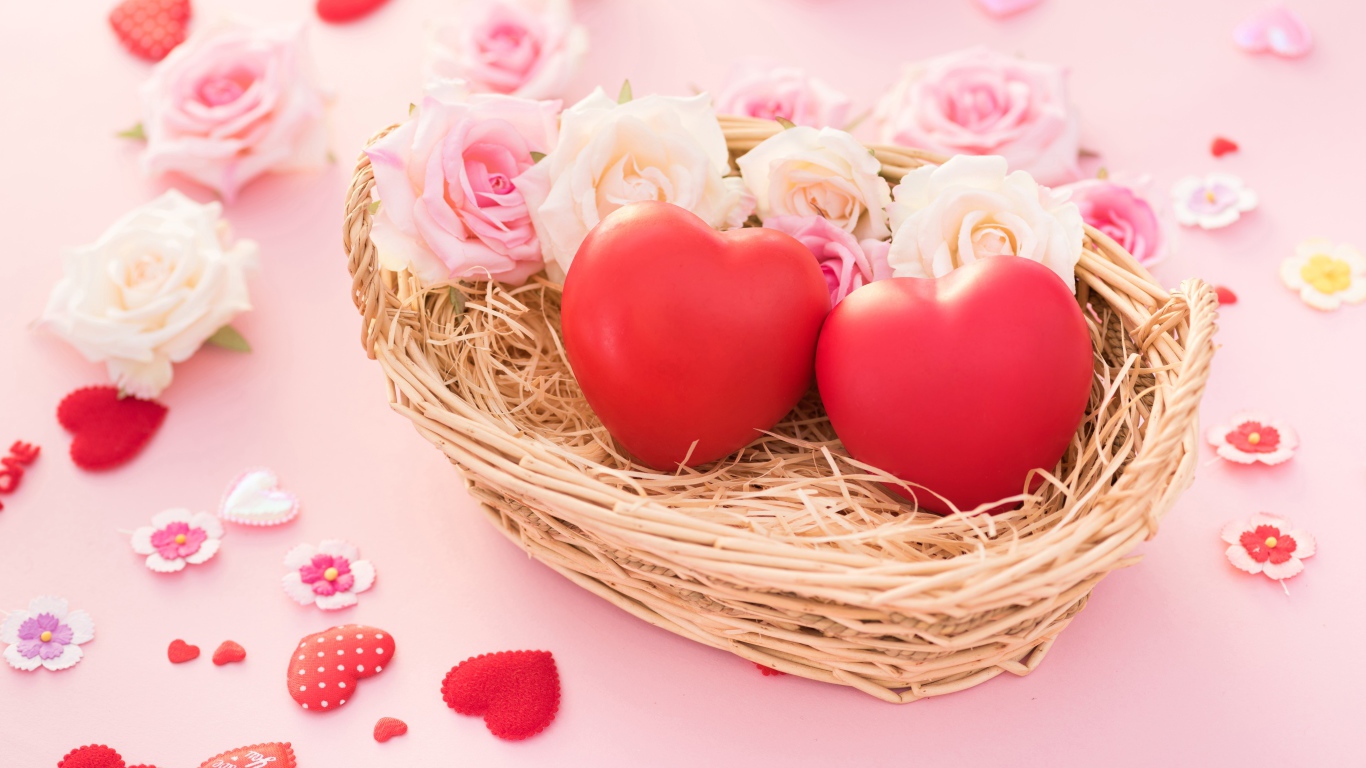 Два красных сердца лежат в корзинке с розами 