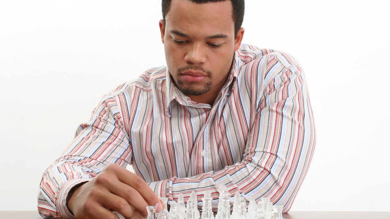 A man in a shirt plays glass chess