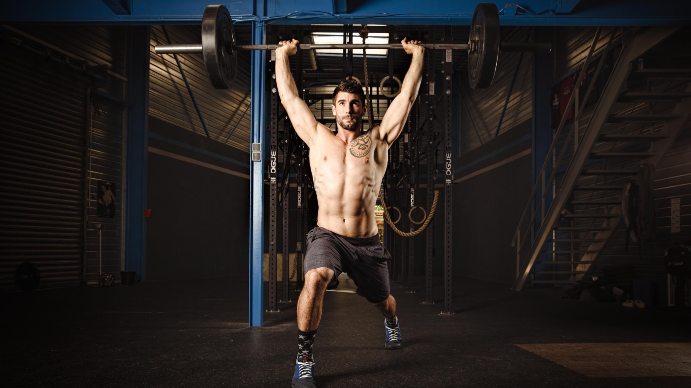 Спортивный мужчина со штангой в руках 