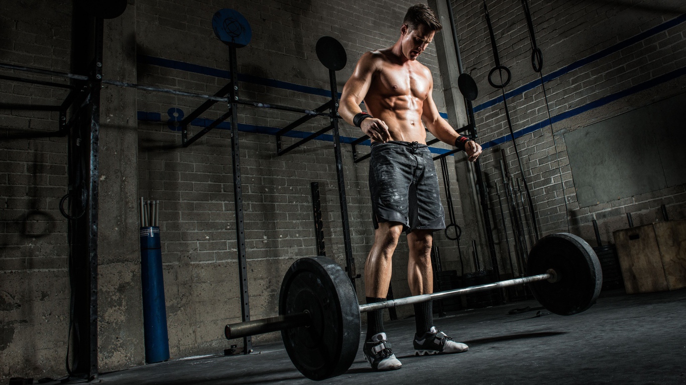 Мужчина спортсмен поднимает штангу в спортзале