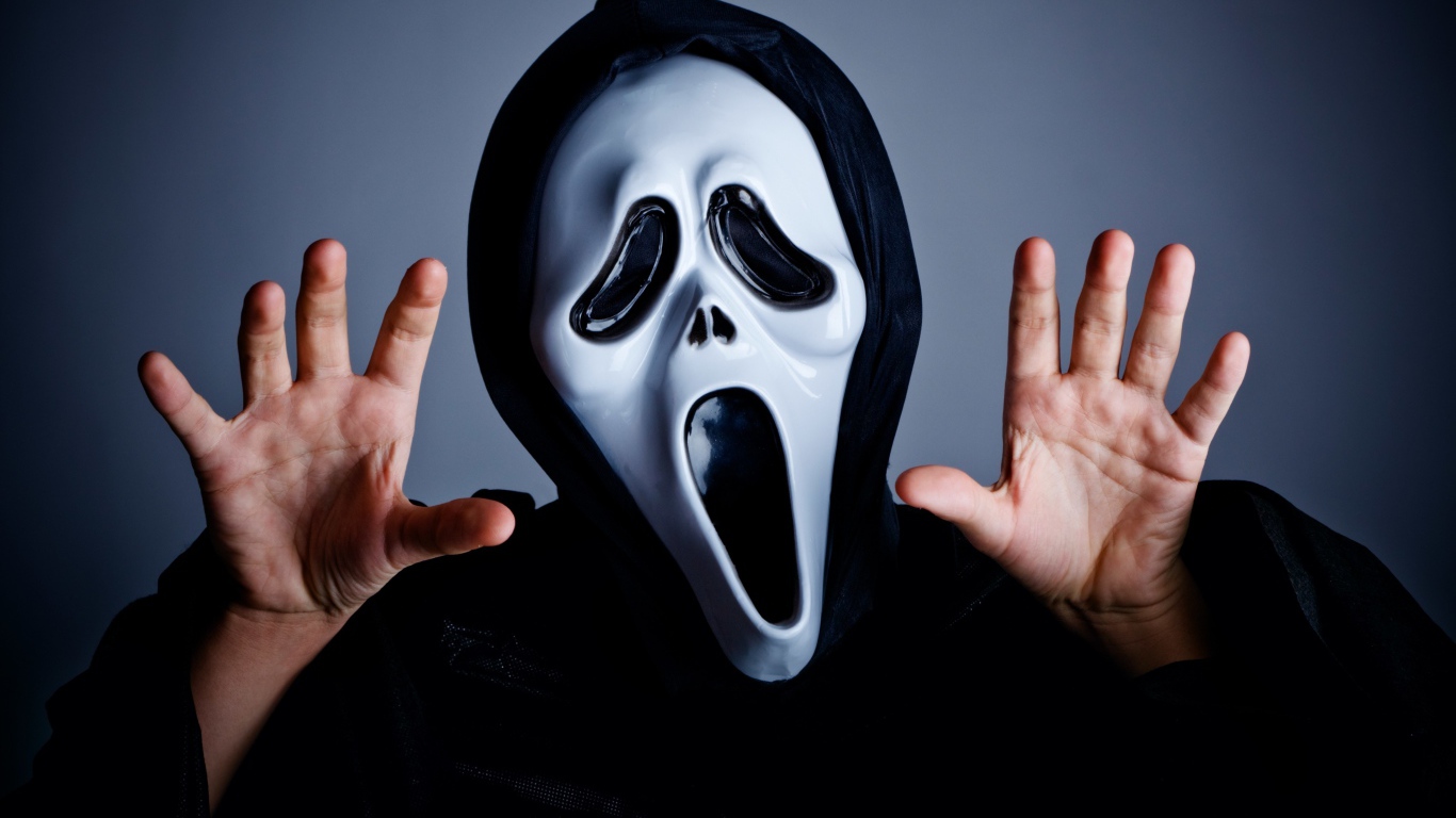 Мужчина в маске пугает на сером фоне