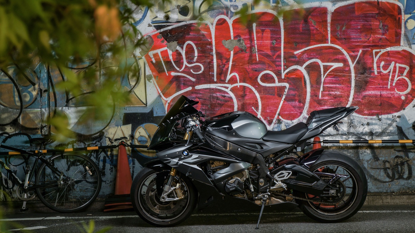 Черный мотоцикл BMW S1000RR на фоне разрисованной стены