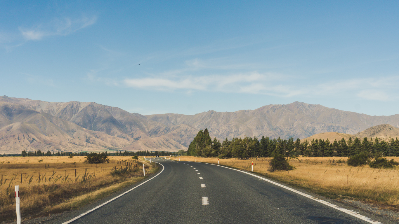 Ровная асфальтовая дорога на фоне гор 