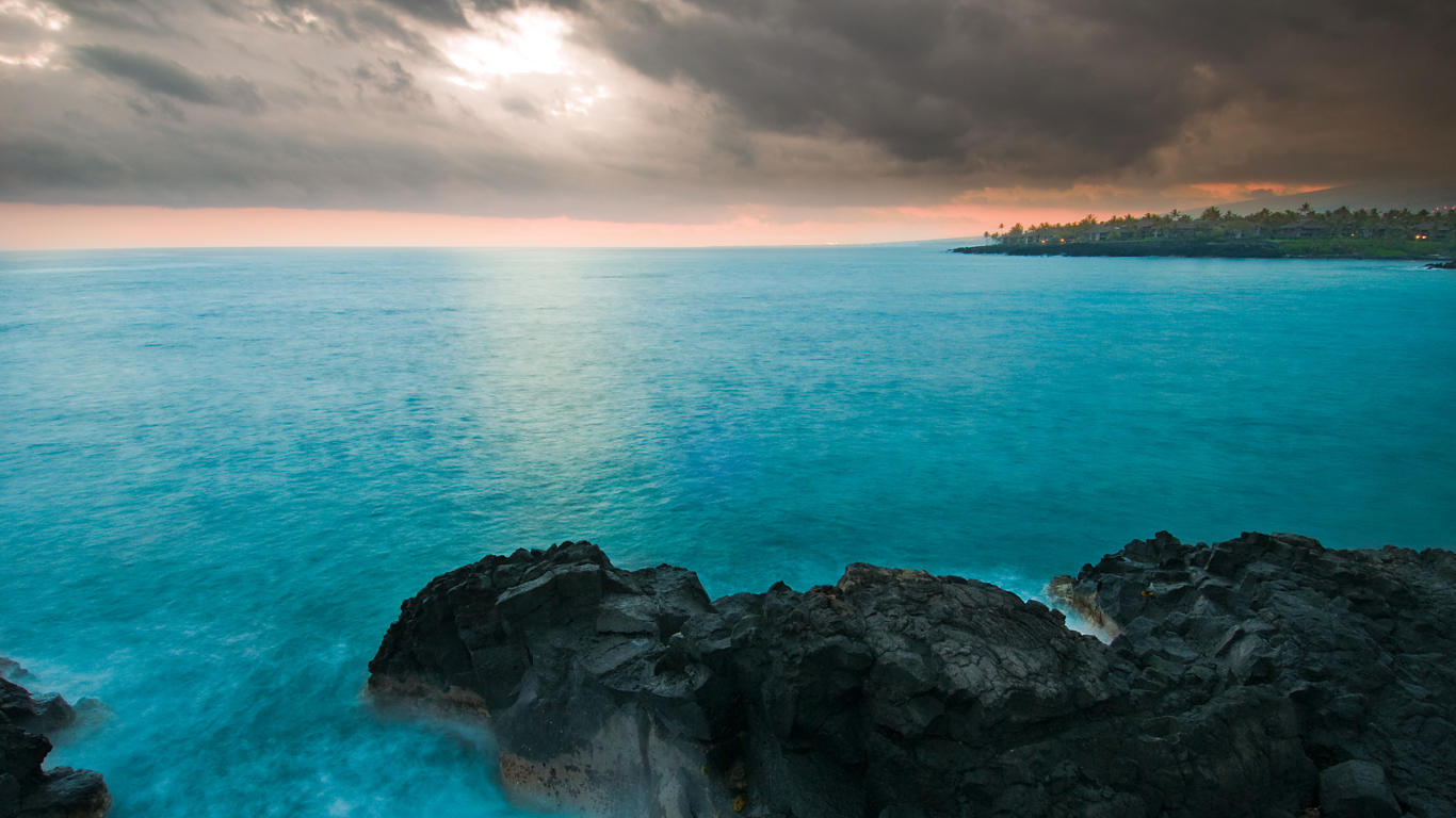 Камни в голубой воде океана под пасмурным небом