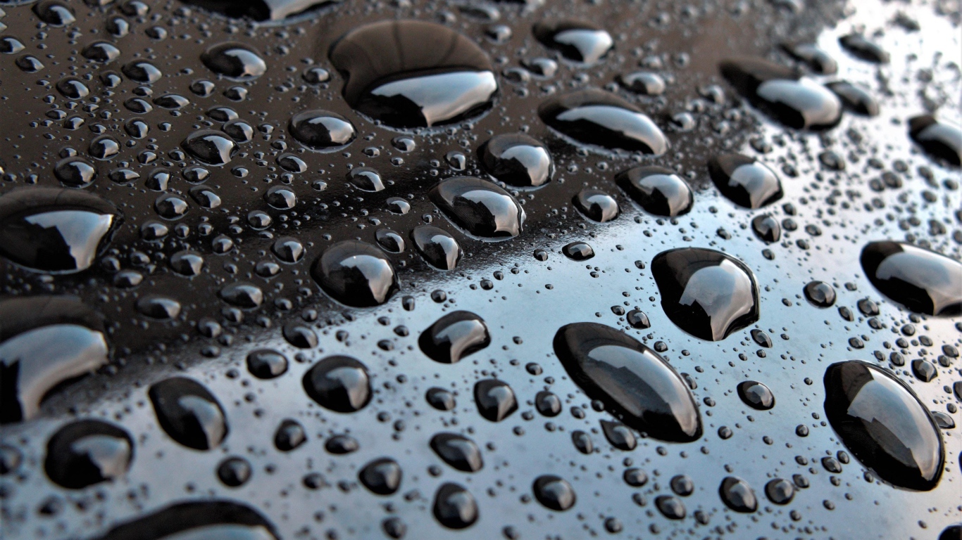 Капли воды на черной глянцевой поверхности 